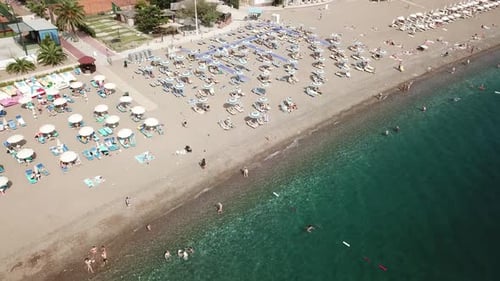 aerial top down of people sunbathing in private resort Bech in Montenegro Adriatic Sea becici holida