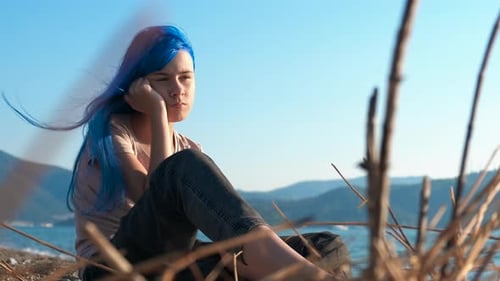 Nachdenklicher blauhaariger Teenager im Freien
