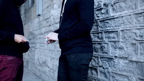 Street drug deal unrecognizable addict buying dose from dealer on the street