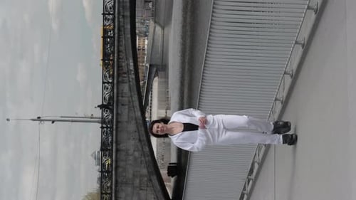 Uma mulher enérgica dá um salto dinâmico no ar em uma ponte vestida de branco capturando a essência