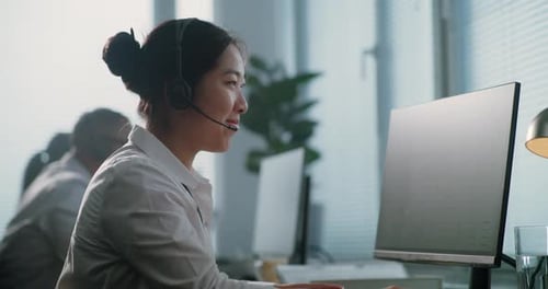 Porträt eines asiatischen Hotline-Betreibers im Call Center, der über ein Headset spricht