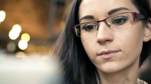 Happy woman browsing internet on tablet computer at modern cafe