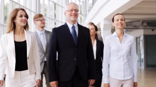 People, Work and Corporate Concept - Happy Business Team Walking Along Office