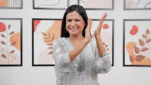 Woman Smiling and Clapping Hands Indoors