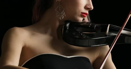 Woman Plays Electric Violin on Black Background