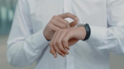 Businessman in a White Shirt Close Up Standing and Tapping with a Finger on His Wristwatch Concept