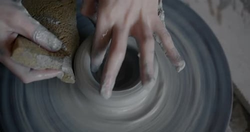 Closeup of Child's Hands Creating Pot Working with Clay on Turning Wheel in Workshop