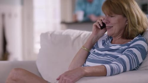 Smiling woman on phone in bright home setting