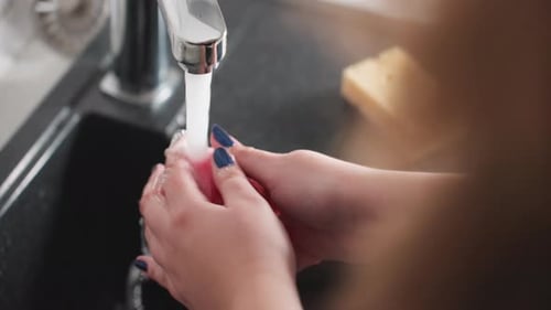 Hands Washing a Fresh Apple in the Sink