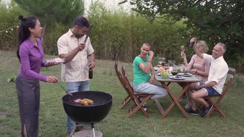 Friends Enjoying Outdoor Barbecue Together in Backyard