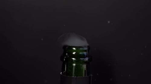 Champagne Bottle Bursting with White Foam on Black