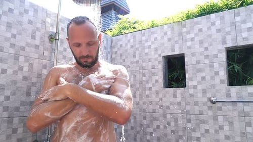 Man Showering Outdoors Applying Soap and Water