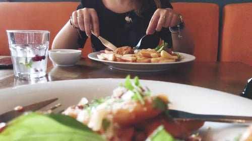 Young attractive girl eating delicious dinner in restaurant. Fresh fish and chips with great colorfu