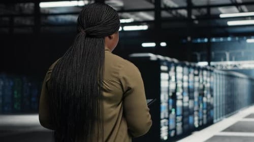 Software Developer Runs Equipment Checkups with Green Screen Laptop and Tablet in Data Center