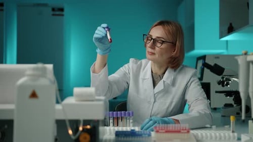 Female Scientist Examining Blood Sample in Laboratory