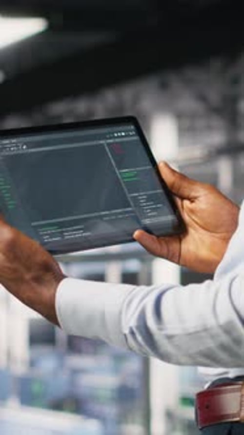 Vertical Video Close Up of Data Center Programmer Looking at Code Debugging Tools on Tablet