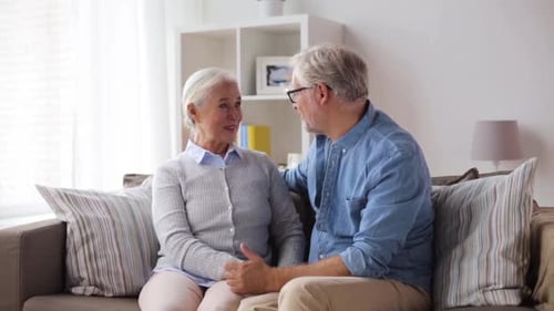 Affectionate Senior Couple Embracing on Sofa at Home