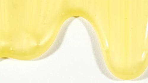 Yellow Cosmetic Gel Fluid With Molecule Bubbles Flowing On The Plain White Background Liquid Cream