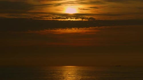 Beautiful View Over Ocean at Sunset with Reflection Ripples on Sea with Dramatic Cloudscape and Dark