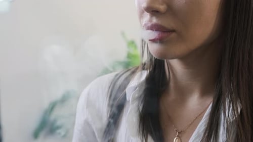 Young Woman Releases Thick Cigarette Smoke From Mouth