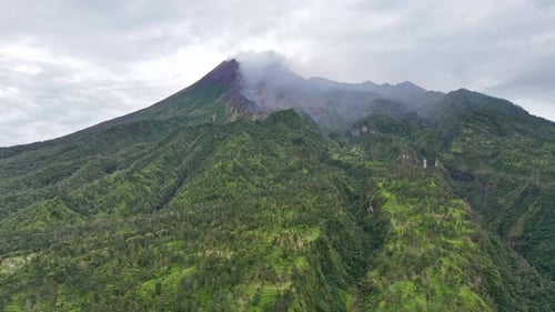 Aerial view of active Merapi Volcano emits smoke from the crater on the top of mountain.