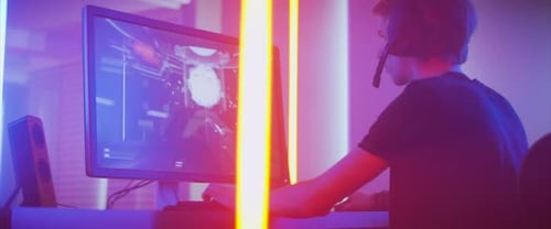 Young Man Plays Video Game with Headset On