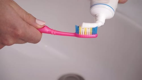 Hand Holds Toothbrush with Toothpaste