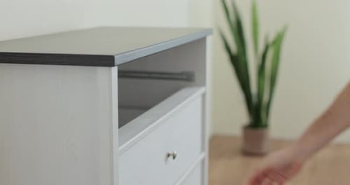 Handyman Installing and Adjusting Drawer Slide Mechanism in Contemporary Kitchen Furniture