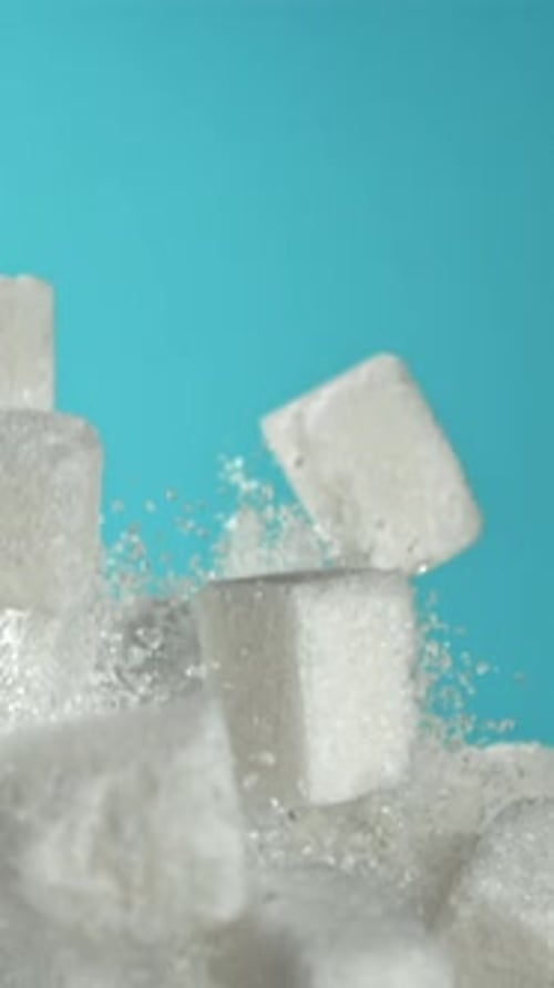 Cubes of Sugar Fly Up and Fall Down on a Blue Background Filmed on a Highspeed Camera at 1000 Fps