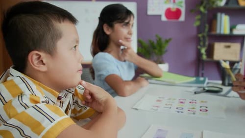 Bi-ethnic Kids Repeating Sounds of English Alphabet after Female Teacher