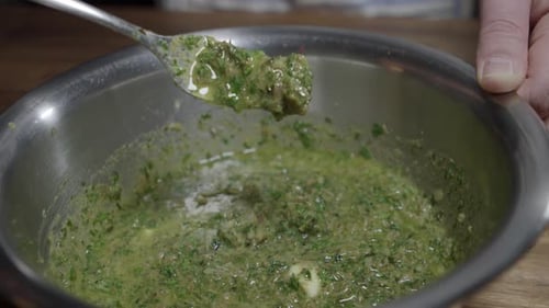 Delicious café de paris sauce is prepared by a chef. Mixing all ingredients in a metal bowl. No face