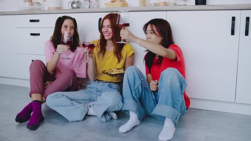 Women Friends Enjoying Wine and Snacks in Kitchen