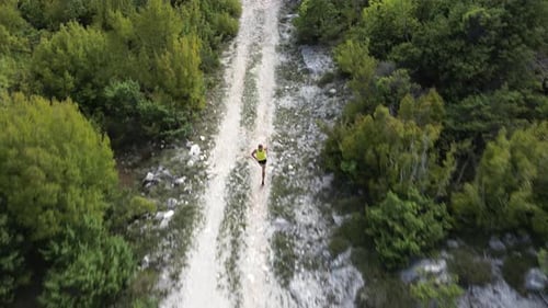 Runner Running Fast on Mountain Road with Trees and Beautiful Landscapes in the Background Aerial