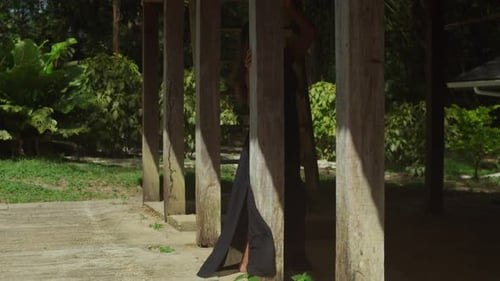 Clad in a black dress, a young girl enjoys the tranquility of the river.