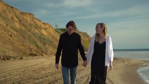A Couple Enjoying a Stroll Together on the Beach While Watching the Beautiful Sunset