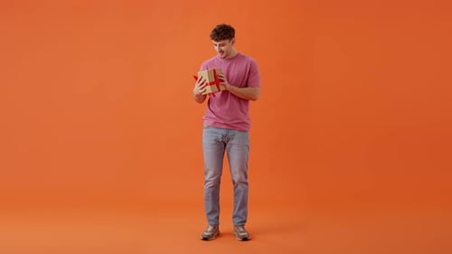 Surprised Man Shaking Gift and Trying to Guess What Inside