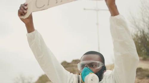 Man Holds Coronavirus Crisis Sign Wearing Protective Gear