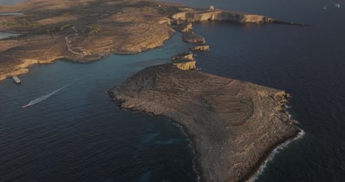 Aerial view of rugged Gozo cliffs and Comino island, Malta.