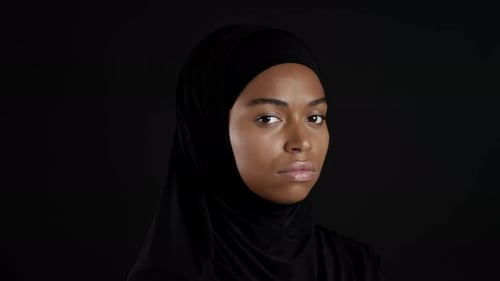 Close Up of Young African American Muslim Woman in Hijab Turning Face to Camera and Looking