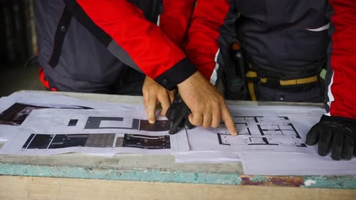 Construction Workers Reviewing Blueprints at Construction Site