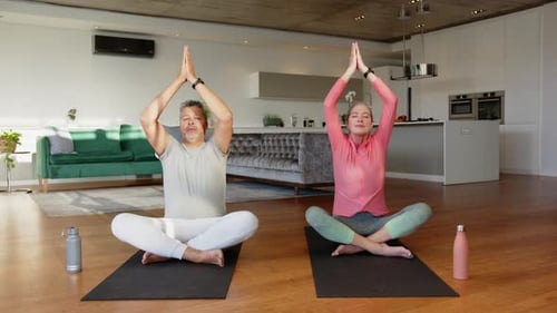 Couple Doing Yoga at Home in Bright Living Room