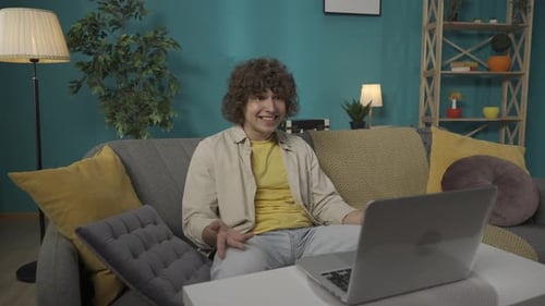 Young Adult Chatting on Laptop in Living Room