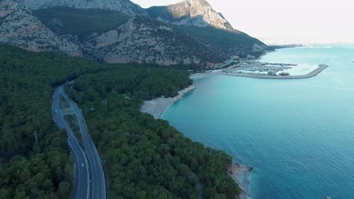 The Camera Flies Along the Coast Over the Road on Which Cars are Traveling