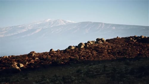 Landscape View of Rocky Terrain and Distant Mountains During Twilight Hours