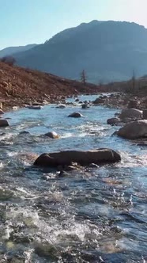 Majestic River Flow Vertical Video of Rushing Waters Carving Through Rocky Landscape