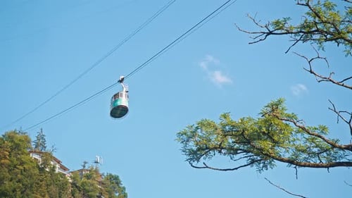 Cable Car Ascending Over Lush Green Mountain