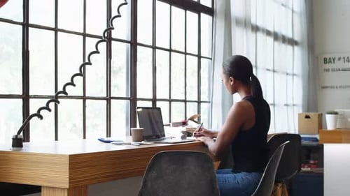 Female Business Owner Working at Laptop on Desk at Office Window Adult