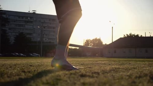Legs of Young Man Kicking Ball at Green Field Male Feet of Professional Footballer Juggling Soccer
