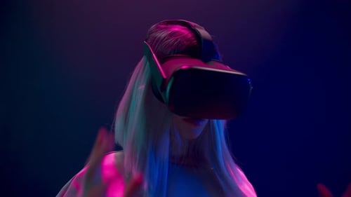 Woman Uses VR Headset in Neon Lit Room