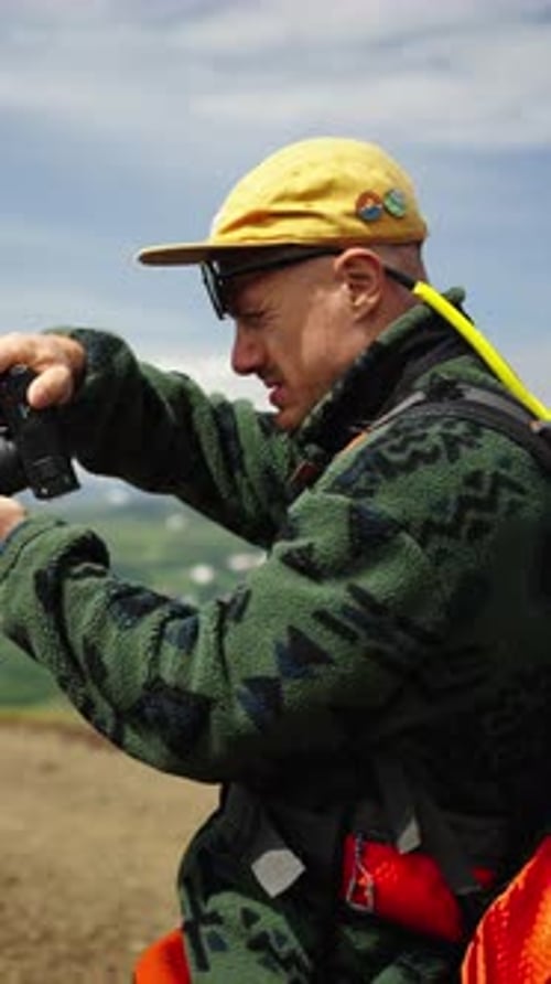 Man Taking Photographs on Camera Outside During Day